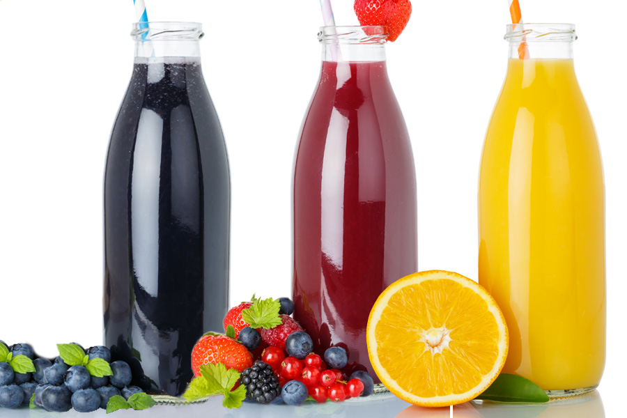 Opskrift Sort-Rød-Guld Frugt Smoothie Gruppe på tre gennemsigtige bredmundede flasker fyldt med sorte, røde og gule smoothies og et sugerør hver, dekoreret med frugt