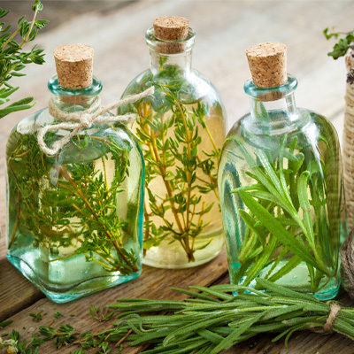 Tre klare glasflasker fyldt med aromatiseret olie, lukket med en prop
